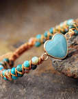 Amazonite String Braided Heart Bracelet beside a stone