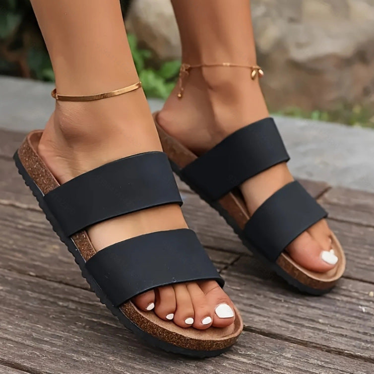 Girl wearing Black colored Beach Open Toe Flat Sandals over wood