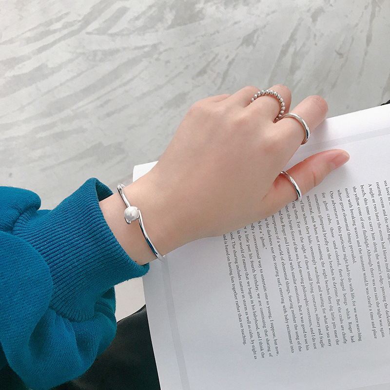 Sterling Silver Bracelet for Female in woman's hand over a book