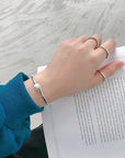 Sterling Silver Bracelet for Female in woman's hand over a book