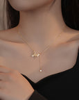 Girl wearing gold colored hollow butterfly necklace