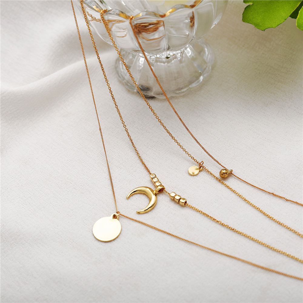 Multi-layer Moon Necklace beside a cup