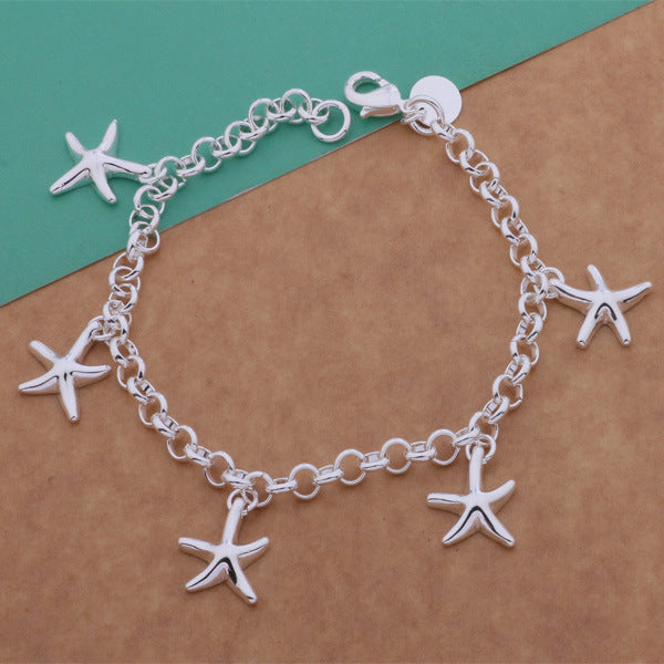 925 Silver Starfish Pendant Bracelet over green and wood table