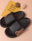 Black colored Cute Bear Slippers Summer Beach Shoes beside wool ball